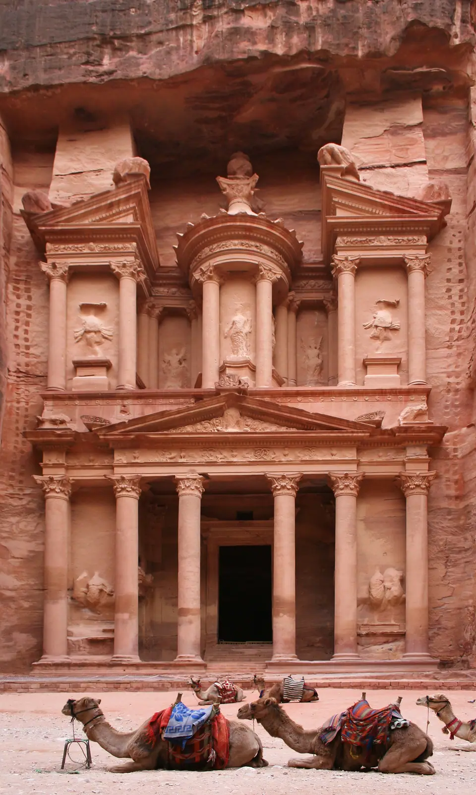 La fachada del Tesoro (Al-Khazneh) de Petra, tallada en la roca, con camellos en primer plano